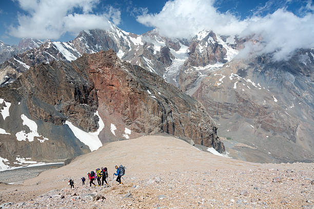 istock Mountain View and Backpackers Team Walking on Rocky Trail 487980762