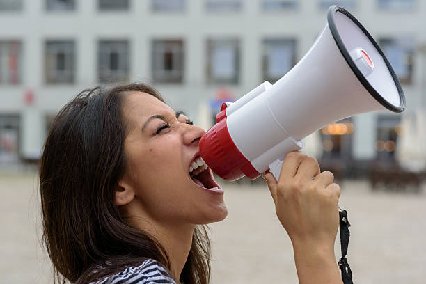 frau mit schreien in ein schalltrichter auf der urban street - picket line fotos stock-fotos und bilder