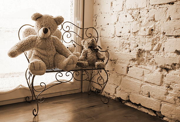 three vintage soft toy bear sitting on a bench on the windowsill