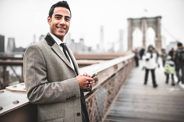 istock young Businessman entrepreneur messaging on the brooklyn bridge 488004093