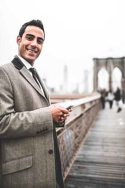 istock young Businessman entrepreneur messaging on the brooklyn bridge 488004103