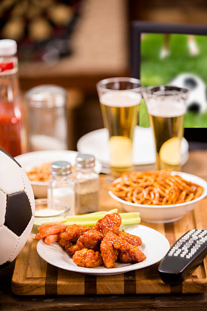 regarder match de football à la télévision au pub local. ailes de poulet. - barbecue foot photos et images de collection