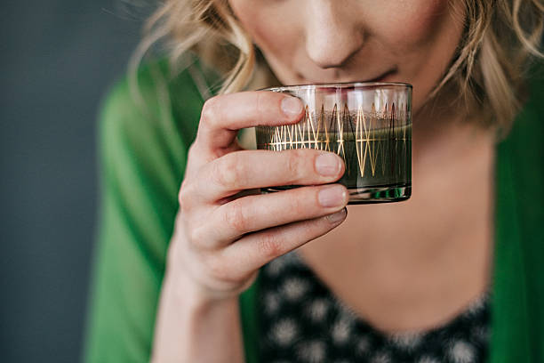 joven mujer beber jugo verde - green drink fotografías e imágenes de stock