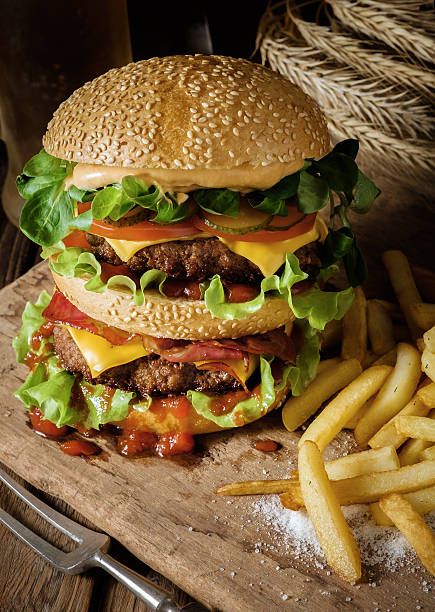 istock Delicious beef burger with chips and beer on wooden table. 488015488