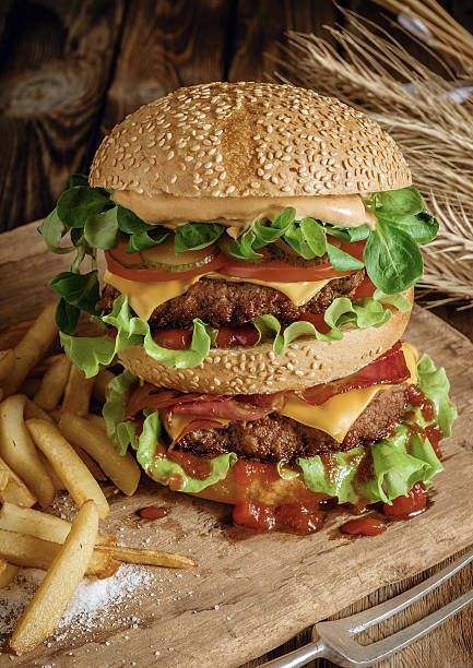 istock Delicious beef burger with chips and beer on wooden table. 488015974