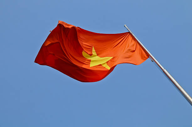 istock Vietnam national flag flying in blue sky 488025931