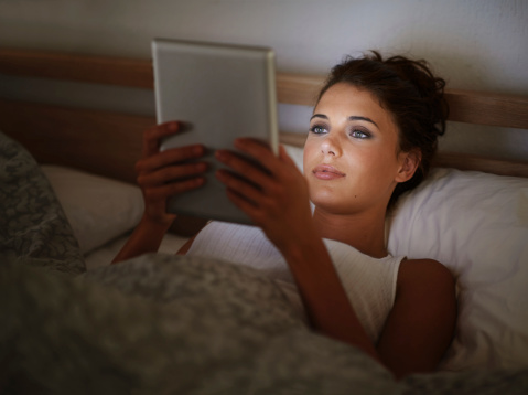 Cropped shot of an attractive young woman using her tablet in bed