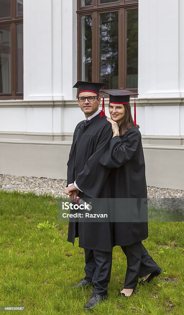 Couple in the Graduation Day Young couple in the graduation day posing outside in front of the University wall. Achievement Stock Photo