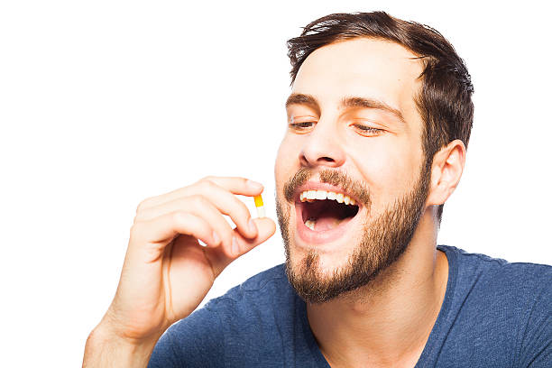 Handsome man showing pills stock photo