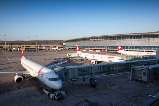 Zürich, Switzerland - March 02, 2012: Five Airbus A320 of Swiss International Air Lines and Germanwings in front of Dock A and Airside Center at Zurich International Airport. Some workers are working at the airport area.