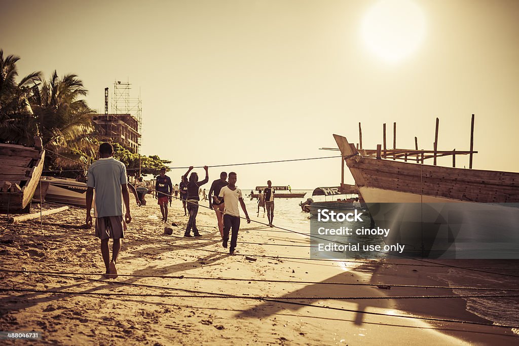 Sunset Stone Town Beach Zanzibar, Tanzania - October 18, 2013: Local people on sunset at the beach of Stone Town the capital of Zanzibar- Africa Stock Photo