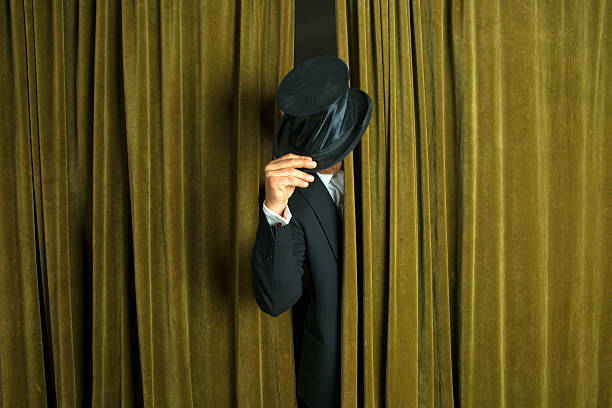 istock Actor with opera hat appears from behind the curtain. 488048095