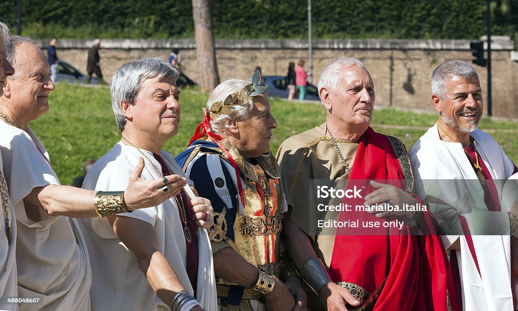 Senators and Julius Caesar rome, Italy - April 21, 2014: a few Senators and Julius Caesar posing for photographers before the show taking place in Circo Massimo for Rome's Foundation Celebrations. This event has been organized by Gruppo Storico Romano and involved 9 different countries, 1600 people and 42 different volunteer associations. All the costumes are historically correct thanks to the supervision of a team of archeologists and researchers. The leading volunteer group of Gruppo Storico Romano was born in 1994. By now, the group has highly increased and has a scientific department of experimental archeology which expresses itself by recreating ancient situations such as parties or gladiators' fights and dances. Julius Caesar - Emperor Stock Photo
