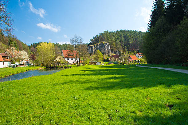 A wonderfully fresh motif of a landscape idyll of Franconian Switzerland in Germany. The sunny morning makes the grass shine.