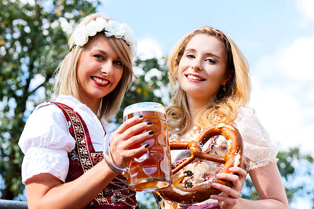 две женщины с дирндл и пиво - german culture people women germany стоковые фото и изображения