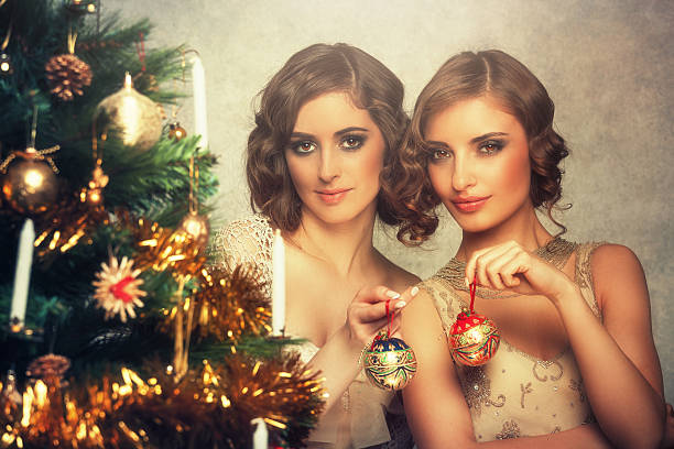 istock retro christmas - girls decorating a christmas tree 488052452