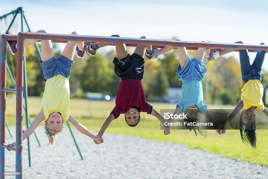 Recess Kids playing outside on a jungle gym during recess. Child Stock Photo