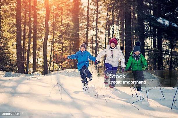 Kids Playing In Winter Forest Stock Photo - Download Image Now - Child, Running, Snow