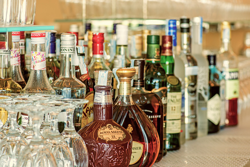 Herceg Novi, Montenegro - July 17, 2015: Liquor on display: A horizontal shot of a large collection of assorted bottles of alcohol. Visible in this image are Monini products, Royal Salute, Curvosier, and more. Brandnames and logos are visible. Editorial use only