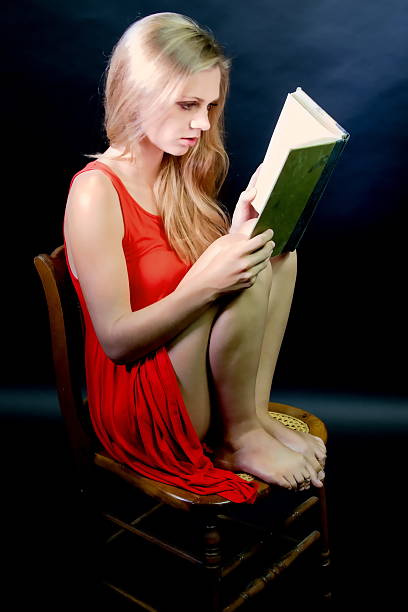 istock Young  Female Reading With Bare Feet On A Chair 488056176
