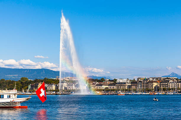 Water jet fountain with rainbow in Geneva Beautiful view of the water jet fountain with rainbow in the lake of Geneva and the cityscape of Geneva at sunset, Switzerland geneva switzerland photos stock pictures, royalty-free photos & images