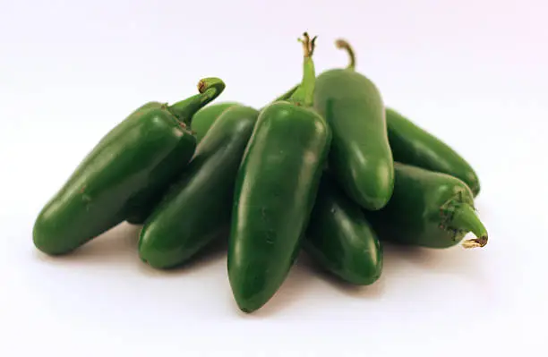 A stack of green jalapeños. 