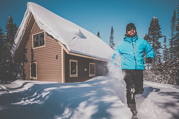 hombre corriendo con snowshoes y chalet de madera en la nieve en polvo - winter snowshoeing running snowshoe fotografías e imágenes de stock