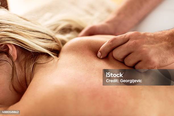 Receiving A Shoulder Blade Massage Stock Photo - Download Image Now - 2015, Adult, Adults Only