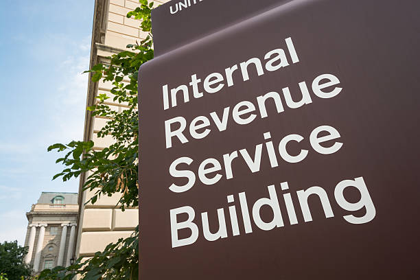 Internal Revenue Service (IRS) Building in Washington, DC Washington, United States - August 18, 2014: A sign saying "Internal Revenue Service Building" stands outside the Internal Revenue Service (IRS) building. The IRS is responsible for collecting taxes in the United States as well as the administration of the Internal Revenue Code and has 89,500 employees. Annually, it collects approximately $2.4 trillion in taxes.  IRS Headquarters Building stock pictures, royalty-free photos & images