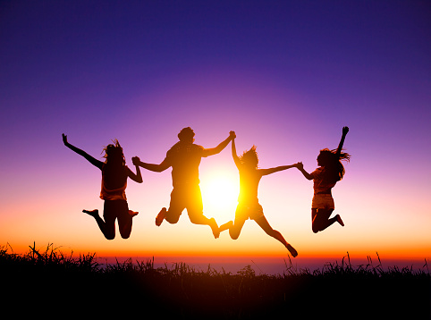 group of happy young people jumping on the mountain