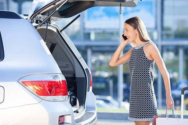 istock Beautiful young woman is using phone near her transport 488064196