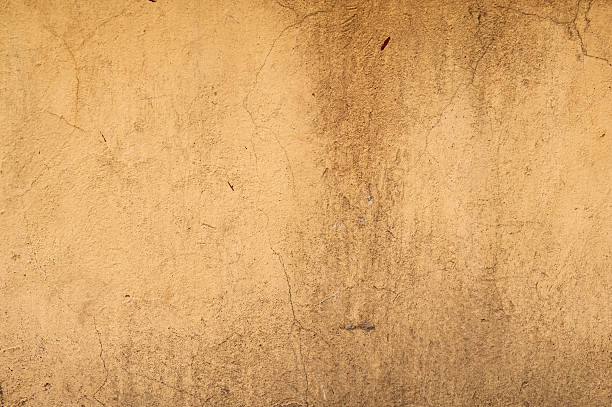 istock Texture of old wall covered with yellow stucco 488064348