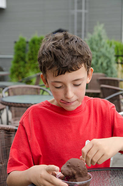 junge essen eis mit schokolade - child chocolate ice cream human mouth stock-fotos und bilder