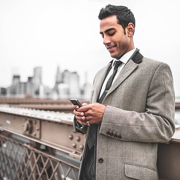 istock young Businessman entrepreneur messaging on the brooklyn bridge 488076121