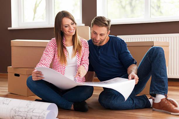istock Loving couple checking blueprints of new home 488077335