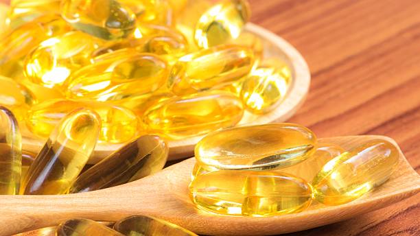 istock Fish oil capsules on wooden spoon 488079594