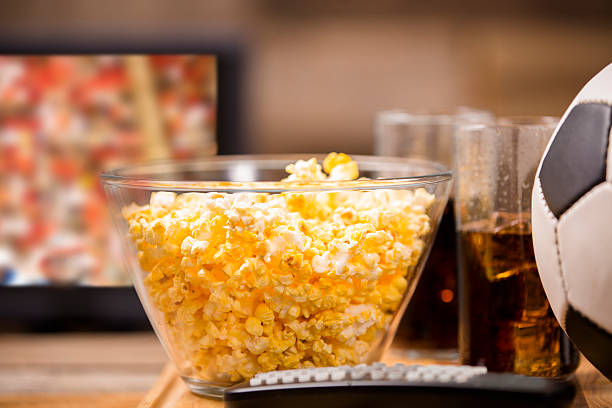 Soccer game on television at pub or home. Popcorn. Ball.