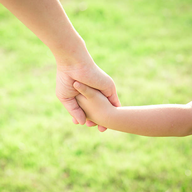 istock Hands of mother and son holding each other 488083150