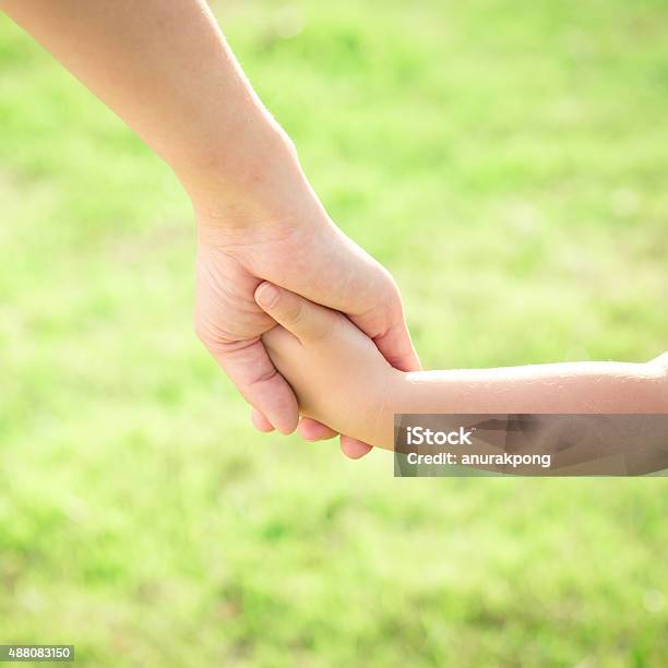 Hands Of Mother And Son Holding Each Other Stock Photo - Download Image Now - 2015, Adult, Asian and Indian Ethnicities