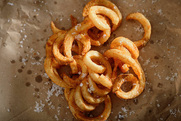 Spicy Seasoned Curly Fries Curly Fries close up curly fries stock pictures, royalty-free photos & images