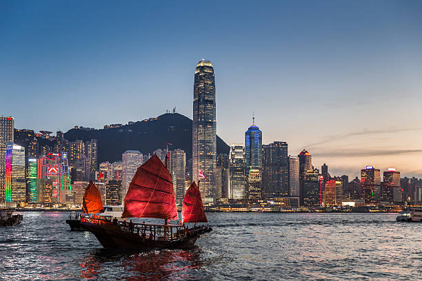 traditionelle dschunke in der dämmerung - hong kong cityscape flowing water built structure stock-fotos und bilder