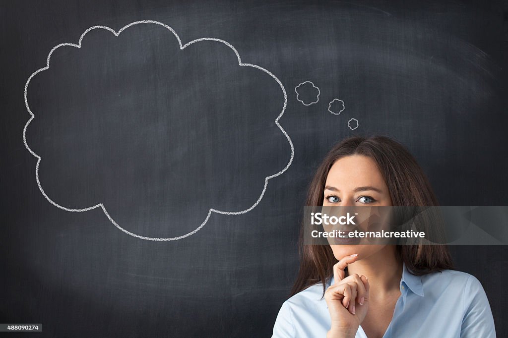 Business woman has something brilliant in mind Young woman think at a blank blackboard Thought Bubble Stock Photo