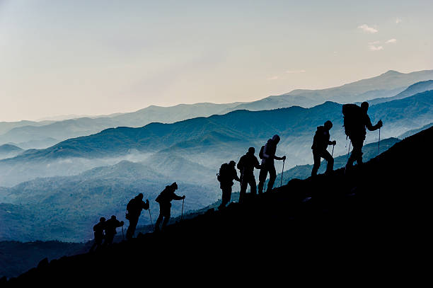 silhueta de quem gosta de caminhadas ao anoitecer - climbing clambering mountain silhouette - fotografias e filmes do acervo