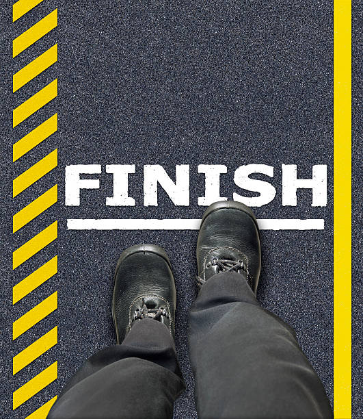 istock man with shoes stepping on finish line 488097315