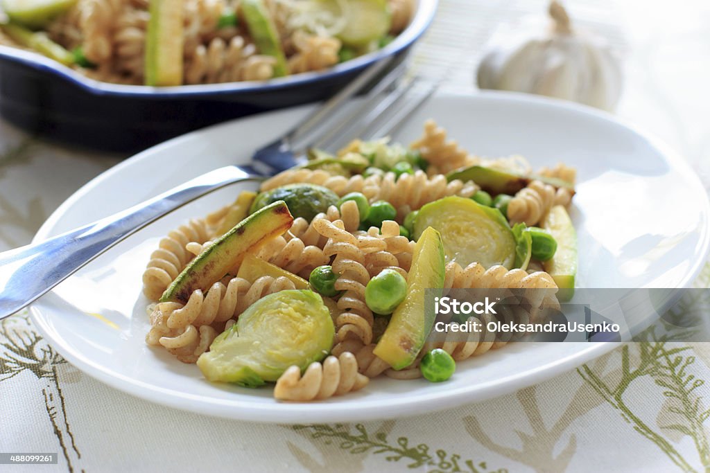 Grano entero pasta con frijoles verdes, zucchini y Bruselas sprouts - Foto de stock de Aceite de oliva libre de derechos