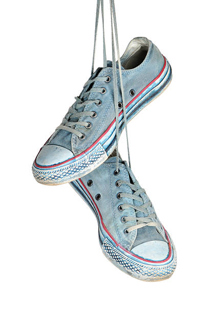 istock Pair of blue sneakers hangs on the laces. 488101779