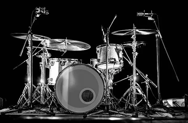 Drum kit set on a stage with microphones, ready for the show.