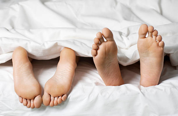istock Closeup Of Barefeet In Bed 488103587
