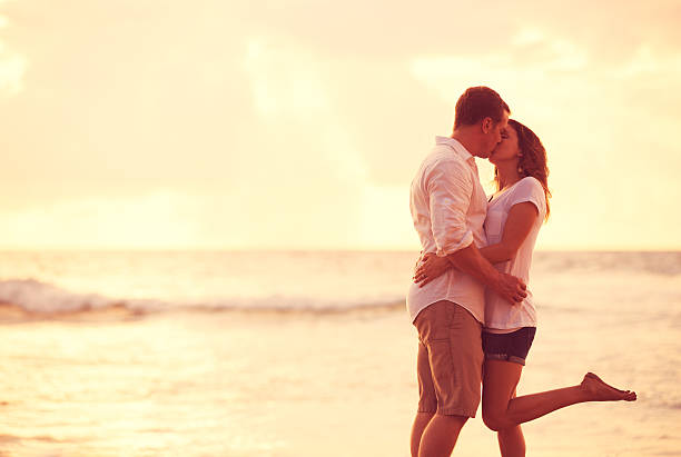 istock Romantic Couple Kissing on the Beach at Sunset 488107722