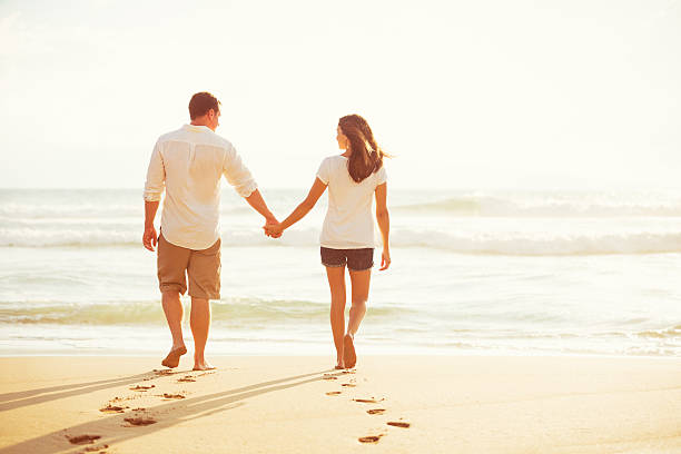 istock Couple Walking on the Beach at Sunset 488107896
